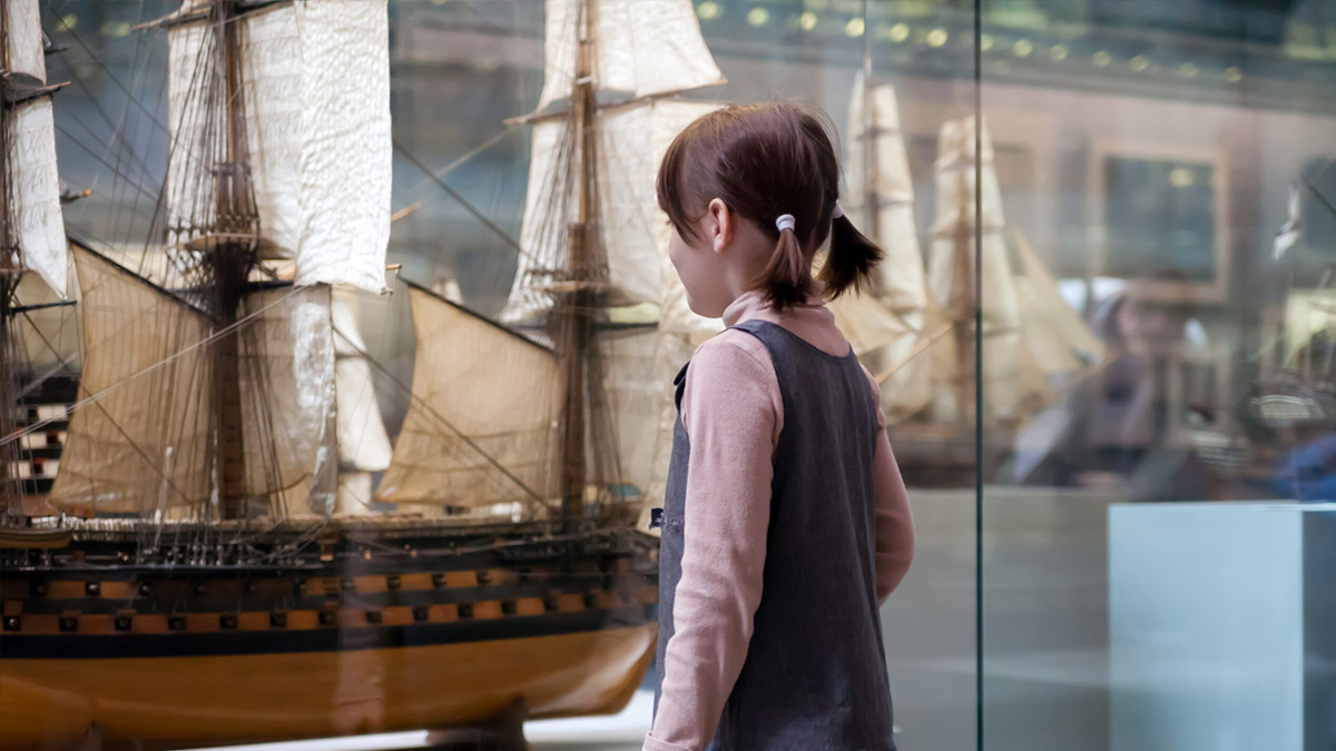 Girl standing in front of model ship